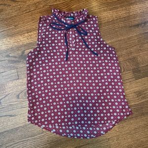 Sleeveless top with ruffle neck